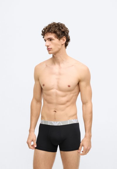 Czarne bokserki z szarą elastyczną gumką w pasie, na której powtarza się logo marki. Materiał wygląda na gładki i przylegający do ciała.