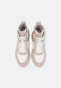 High-top sneakers featuring white leather and beige suede panels, perforated toe box, white laces, and a side zipper detail.