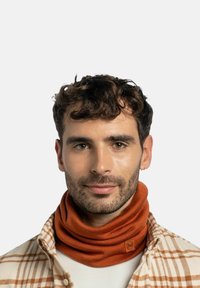 Orange neck gaiter made of soft fabric, featuring a logo patch and a snug design. Worn by a person in a checkered shirt.