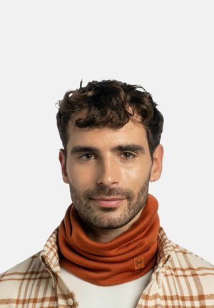 Oranges Halstuch aus weichem Stoff, mit einem Logopatch und passgenauer Form. Getragen von einer Person in einem karierten Hemd.