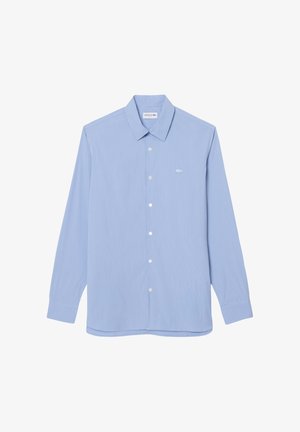 Camicia a maniche lunghe azzurro chiaro con sottili righe bianche e un piccolo logo ricamato a forma di coccodrillo sul petto sinistro.