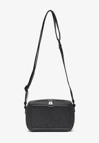 Black leather crossbody bag with a zip closure, embossed logo on the front, and adjustable strap. Smooth texture with a rectangular shape.