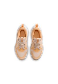 Zapatillas ligeras con parte superior de malla en color durazno y blanco, con cuello acolchado, correa ajustable y suela texturizada.