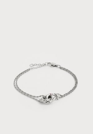 Sølv vridd kjede armbånd med en sentral knute-design med en rød aksent. Justerbar lengde med sikker lås.