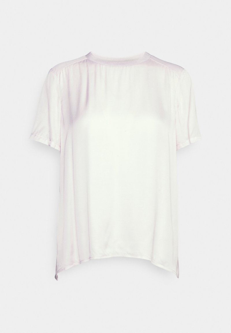 Blouse blanche en satin à manches courtes, col rond et légers fronces aux épaules, sur fond uni.