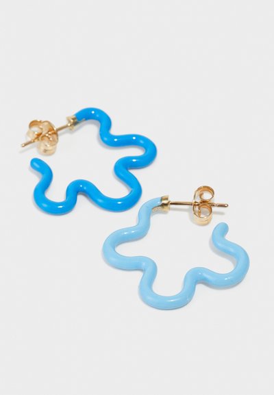 Μπλε και ανοιχτό μπλε κυματιστά πλαστικά σκουλαρίκια με χρυσή μεταλλική βάση, διαθέτοντας έναν μοναδικό, αφηρημένο σχεδιασμό και γυαλιστερή επιφάνεια.