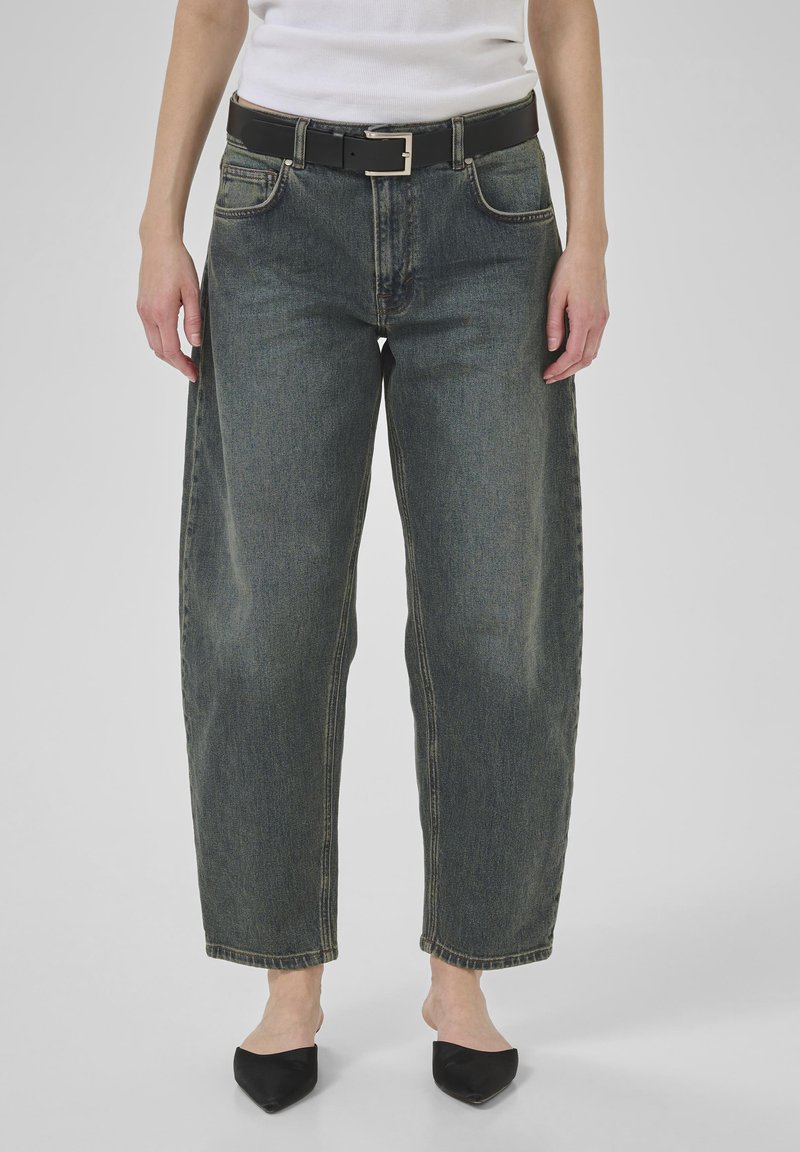 Tumši džinsu auduma platā kāju bikses ar izbalējušu apdari, ar melnu ādas jostu un kvadrātisku metāla sprādzi. Gluda tekstūra un strukturēta forma.