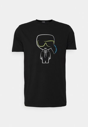 Czarna koszulka z białym konturem postaci z kreskówki noszącej neonowo żółte okulary przeciwsłoneczne, garnitur i krawat, niebieski napis "KARL LAGERFELD" obok okularów.