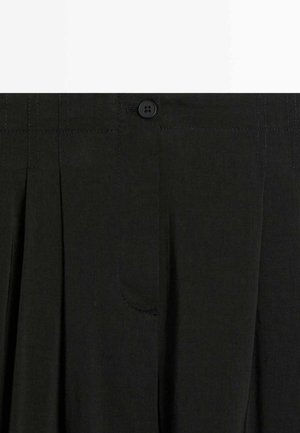 Czarna plisowana spódnica z pasem, zapinana na guzik, z ukrytym przednim zamkiem błyskawicznym.