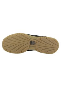 Black athletic shoe sole with a textured rubber design; features a prominent logo at the center and grooves for traction.