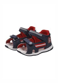 Sandali da bambino blu navy e rossi con cinturini in velcro, punte aperte e suole in gomma bianca; presentano strisce rosse e accenti circolari.