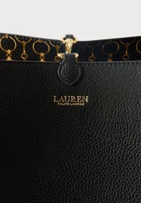 Čierna kožená taška s textúrou a zlatými kovovými prvkami, s logom "LAUREN RALPH LAUREN" vyrazeným zlatom na prednej časti.