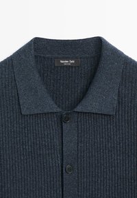 Dunkelgraue, gerippte Strickjacke mit Kragen, zwei schwarzen Knöpfen und einem "Massimo Dutti"-Etikett am Ausschnitt.