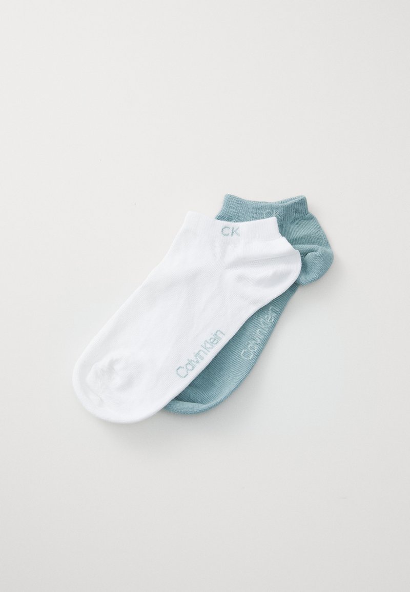 Calcetines de algodón hasta el tobillo en blanco y azul claro. El calcetín blanco tiene "Calvin Klein" en azul claro, y el calcetín azul claro tiene "CK" en blanco. Textura suave.