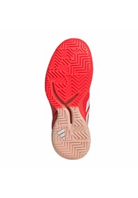 Sole di scarpa sportiva rossa con motivo a zigzag e un logo bianco. La parte superiore è principalmente rossa con strisce bianche.