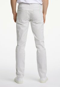 Light grey trousers with a slim fit, made of cotton, featuring two back pockets and a straight leg design, paired with white sneakers.