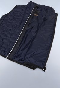 Marinblå puffer-väst med kviltad textur, framsida med dragkedja och sidofickor. Insidan har mjukt foder och detaljer med varumärkesetikett.