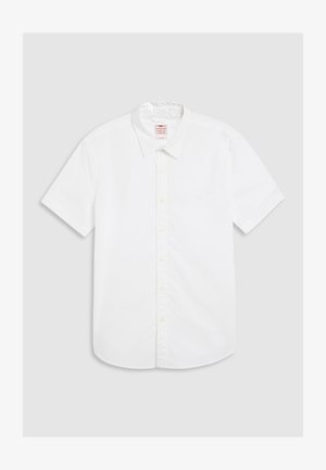 Valkoinen lyhythihainen napillinen paita, joka on valmistettu puuvillasta. Siinä on klassinen kaulus, napitus edessä ja tasku vasemmalla puolella. Sen pinta on sileä.