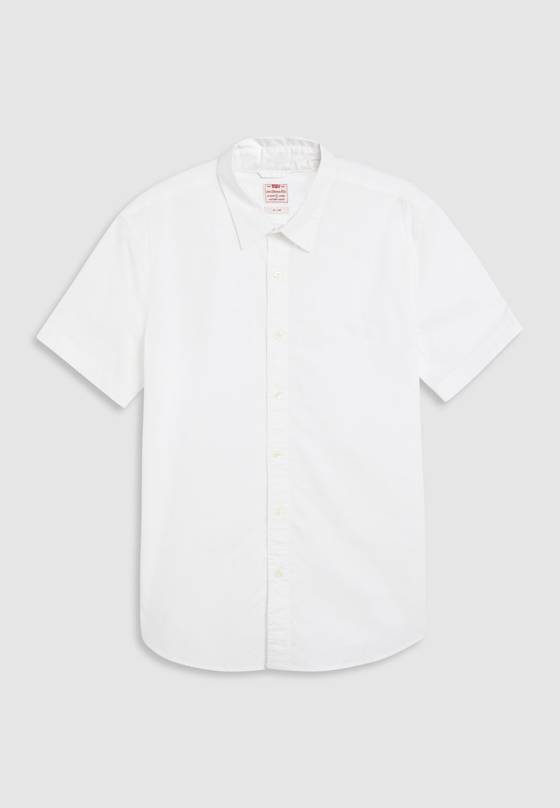 Chemise à manches courtes blanche à boutons en coton. Comprend un col classique, un devant à boutons et une poche sur le côté gauche. Texture lisse.