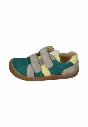 Child’s casual sneaker with green fabric, beige suede straps, yellow accents, and a brown rubber sole, fastened with two Velcro straps.