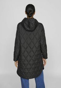 Svart vadderad jacka med huva, med ett diamantmönster. Långa ärmar och medellång design. Slät textur med en subtil glans.
