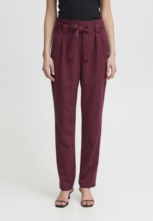 Burgunderfarbene, hochtaillierte Hose mit einem Bindegürtel, Falten an der Taille und einem schmal zulaufenden Bein. Glattes Material mit einem leichten Glanz.