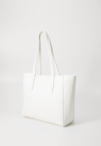 Hvid tote taske lavet af tekstureret materiale, med lange håndtag, rektangulær form og et minimalistisk design. Ingen synlig hardware eller mønstre.