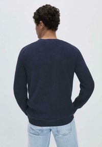 Marineblauer, gestrickter Pullover mit Rundhalsausschnitt, gerippten Bündchen und Saum; verfügt über ein strukturiertes Muster und eine klassische Passform.