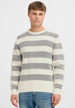Lys kremfarget strikket genser med marineblå horisontale striper, ribbestrikket hals og mansjetter, teksturert stoff og en tettsittende design.