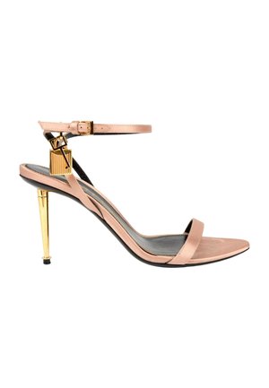 Sandalia de tacón alto rosa con fina correa en el tobillo, tacón de aguja dorado y un pequeño charm de candado dorado unido a la correa.