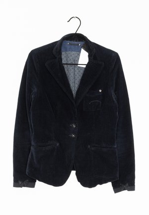 Blazer en velours côtelé bleu marine avec deux poches avant, fermeture par boutons et doublure intérieure subtilement à motifs. Comprend des revers taillés sur mesure et des détails cousus.