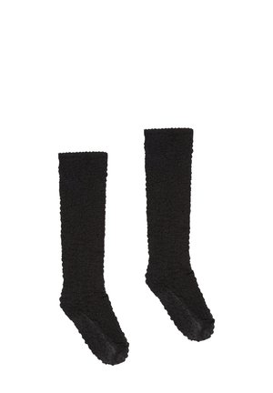 Sorte knæhøje sokker med en tekstureret, fuzzy overflade. Ribbestrikket detalje ved toppen, designet for komfort og varme.