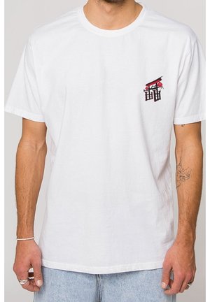 White cotton t-shirt with short sleeves, featuring a small red and black graphic design on the left chest area. Crew neckline.