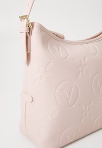 Borsa a spalla in morbido pelle rosa con motivi floreali e logo in rilievo, tracolla regolabile e dettagli in hardware dorato.