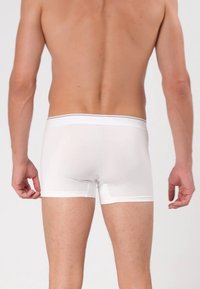 Weiße Boxershorts aus glattem Stoff. Verfügen über einen weichen Bund mit kontrastierender Einfassung, eine figurbetonte Passform und einen Schnitt bis zur Mitte des Oberschenkels.