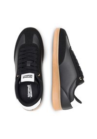 Mustad mustad, mille ülemine osa on valmistatud nahast ja sametist, millel on tekstureeritud tallaosa, ümmargune nina, lipsud ees ja logo keelel.