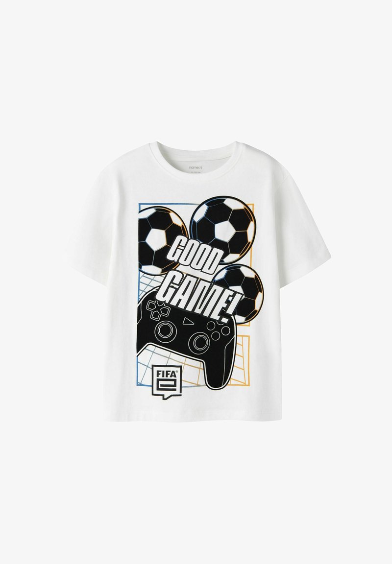 Camiseta blanca de manga corta con un diseño gráfico que presenta balones de fútbol negros, un mando de juego y el texto "¡BUEN JUEGO!" en negrita.