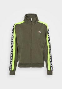 Zielona oliwkowa kurtka zapinana na zamek z wysokim kołnierzem, z neonowo zielonymi panelami bocznymi i czarnymi wstawkami z logo Fila wzdłuż rękawów. Miękka struktura materiału.