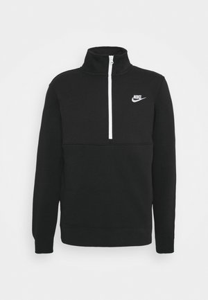 Czarny pulower Nike z długimi rękawami, wysokim kołnierzem i białym półzamkiem, z białym logo Nike na lewej piersi.