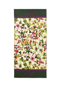 Floral-patterned scarf featuring pink and white flowers on a green background, with purple accents and a branded label at the bottom.