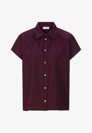 Bluza s kratkim rukavima u burgundijskoj boji, izrađena od glatkog materijala. Ima klasičan ovratnik, nabranu obrubljenost i kopčanje dugmetom sprijeda.