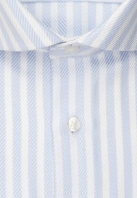 Blauw en wit verticaal gestreepte overhemdenkraag met één knoop vastgemaakt en één knoop zichtbaar eronder.