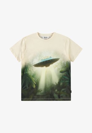 Kreemivärvi puuvillane T-särk, millel on trükitud UFO ja džungli stseen, ümar kaelus ja lühikesed varrukad. Kujunduses on rohelised lehed ja detailid.