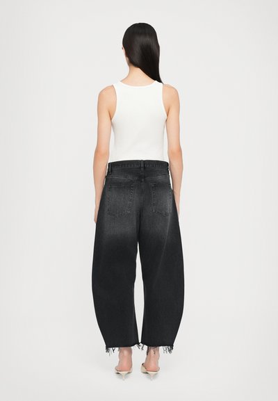 Black denim wide-leg jeans with a frayed hem, featuring a classic five-pocket design and a mid-rise waist. Pair worn with a white tank top.