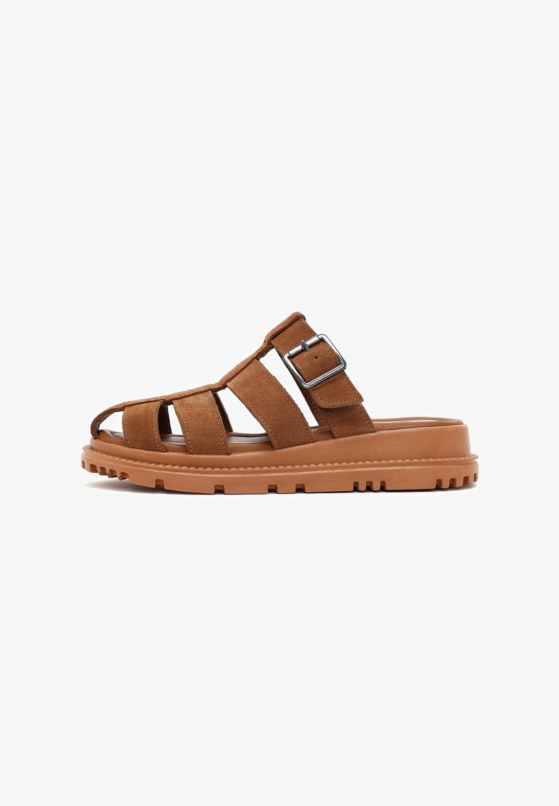 Brown suede sandal with open toe design, three strap detailing, adjustable buckle, and textured rubber sole.