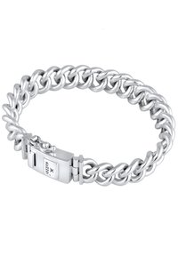 Silverfärgad metallarmband med sammanlänkade länkar, som har en säker låsning med en liten varumärkesdetalj på sidan. Polerad yta.