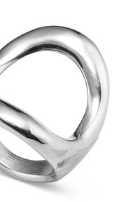 Anillo de plata pulida con un diseño abstracto entrelazado. La textura suave y los bordes redondeados enfatizan la estética moderna. Sin grabados visibles.