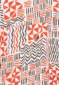 Bavlněná látka s geometrickými vzory v červené, černé a modré barvě na smetanovém pozadí. Textury zahrnují cik-cak, pruhy a trojúhelníky.