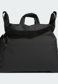 Čierna taška na rukoväť vyrobená z hladkej, odolnej tkaniny. Má dve kratšie rúčky a dlhý popruh, na zadnej strane je vrecko so zipsom.