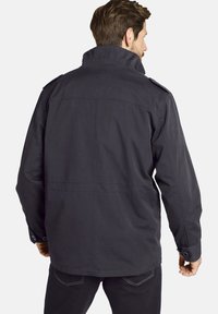 Black, mid-length jacket with a high collar, shoulder epaulettes, buttoned cuffs, and a smooth texture, featuring a simple design.